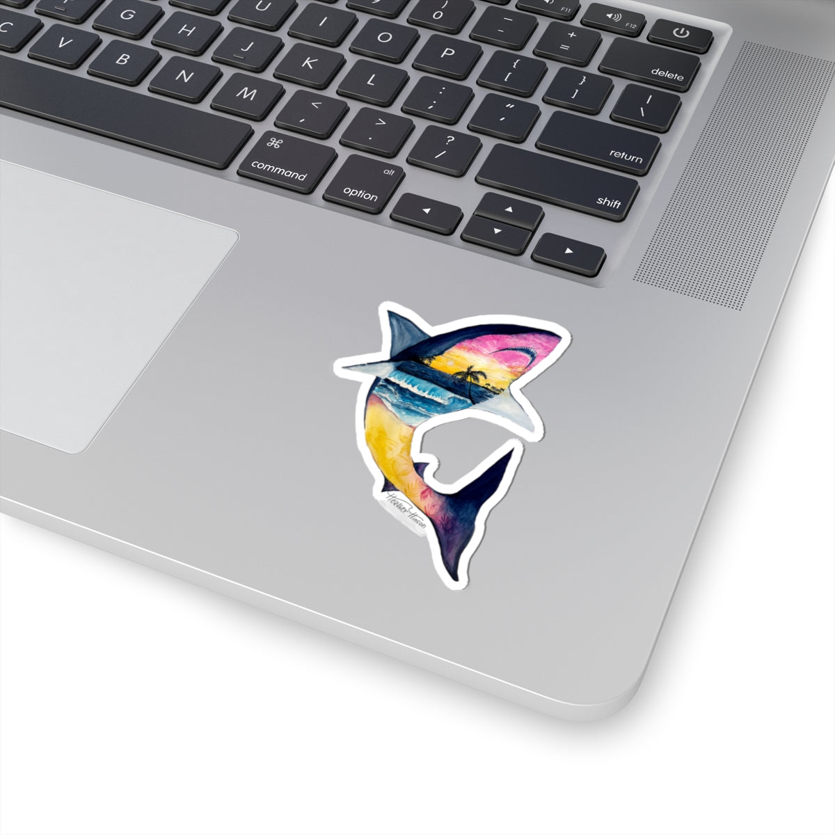 great white shark with sunset and ocean waves set against palm trees, sticker shown on laptop